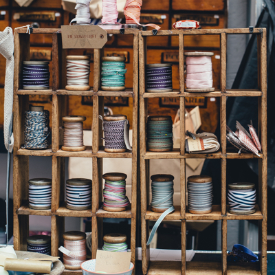two wooden shelves full of various styles of bias tape