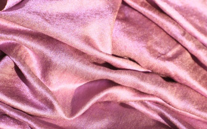 a disheveled pile of glistening soft pink fabric